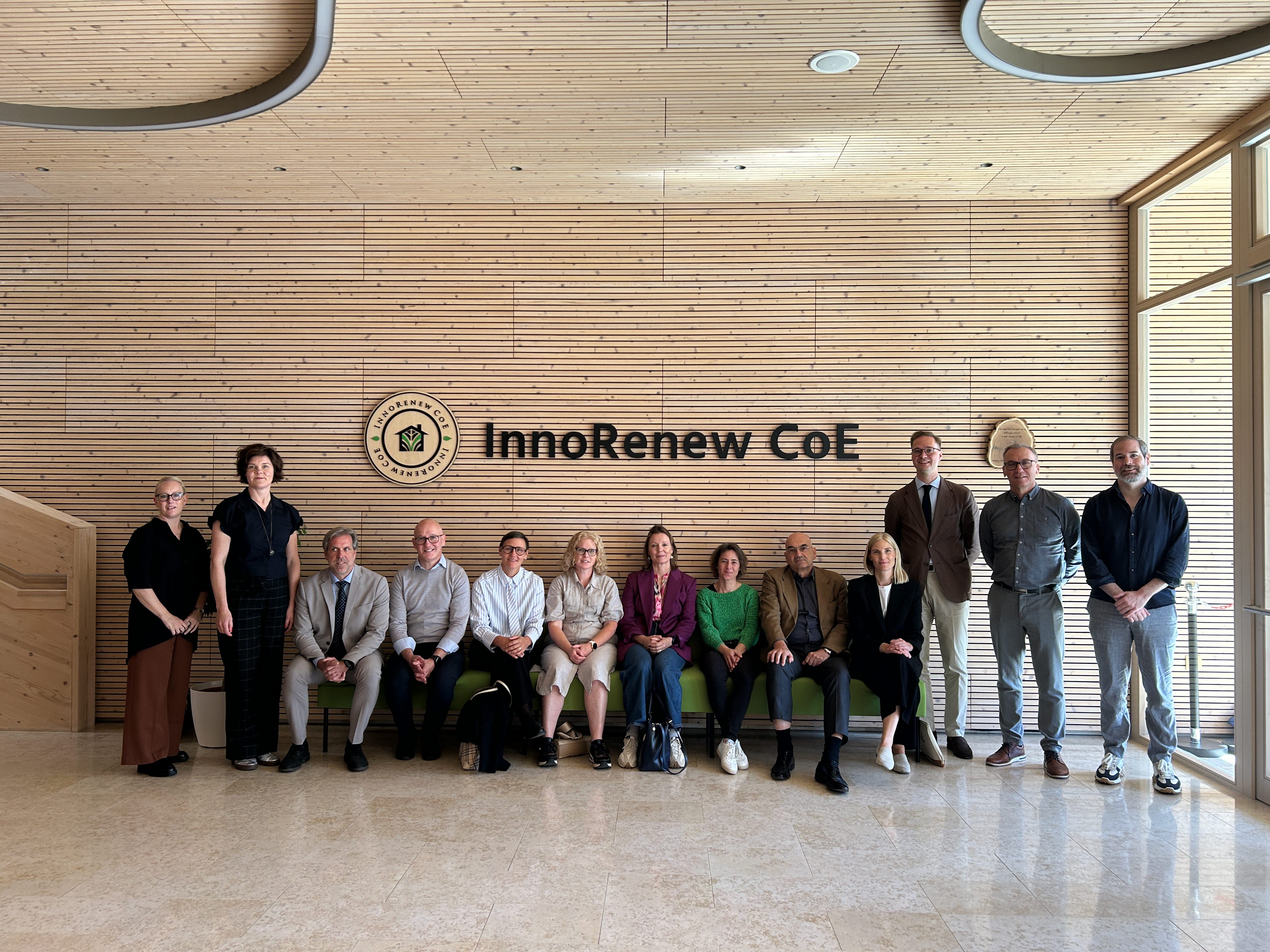 Deltagare från studieresan samlade i InnoRenews reception, med InnoRenews logotyp i bakgrunden.