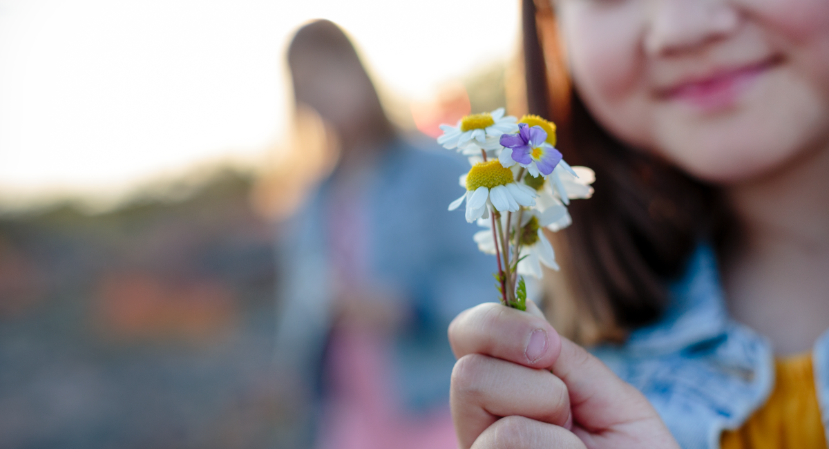 En flicka håller en bukett blommor i handen